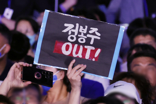 지난 8월18일 서울 송파구 올림픽공원 KSPO돔에서 열린 전국당원대회에서 일부 당원들이 정봉주 최고위원 후보의 사퇴를 요구하는 피켓을 들고 있다.<연합뉴스 자료사진>